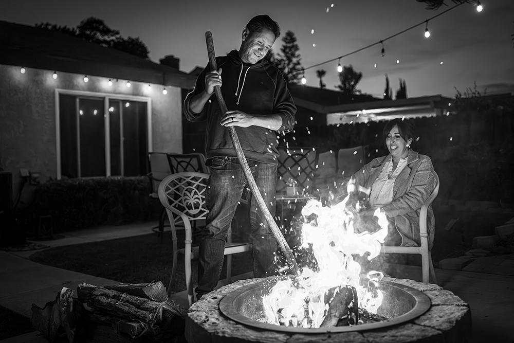 Elias, an adult man living with becker muscular dystrophy, standing by a campfire