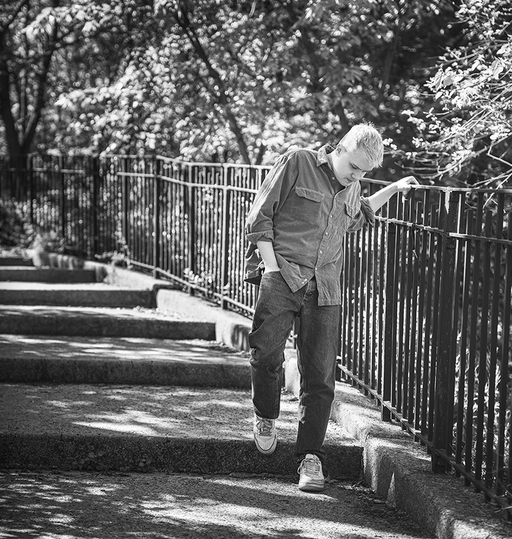 Jess, an adult man living with becker muscular dystrophy, walking down stairs outside