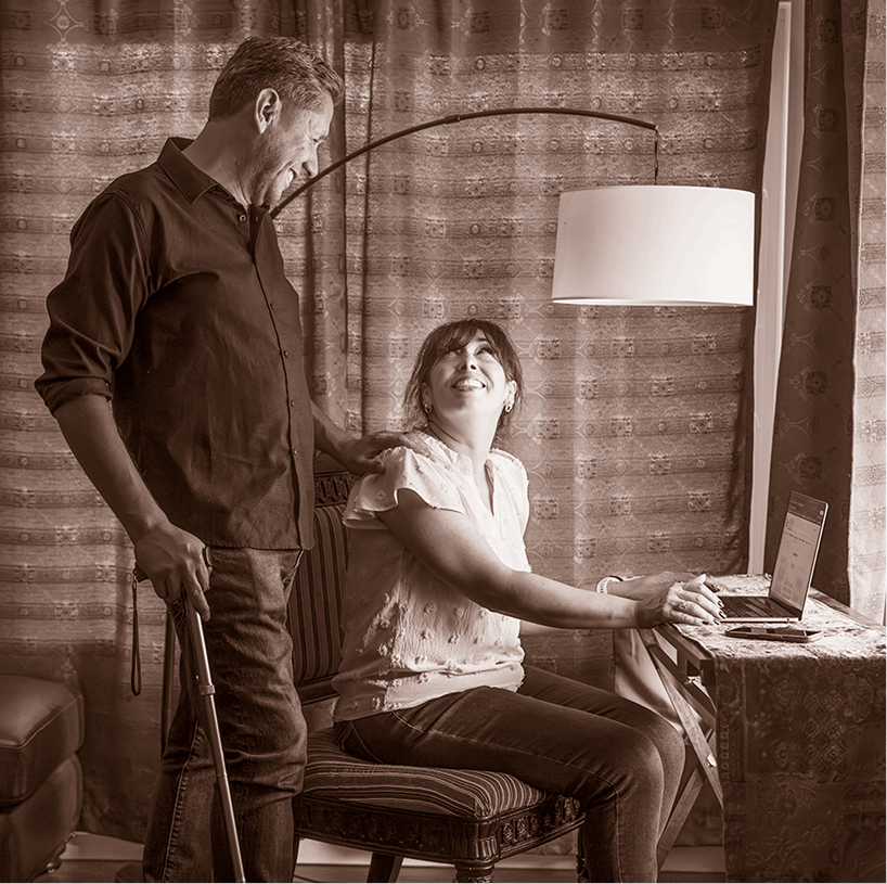 Elias, adult living with becker muscular dystrophy, standing near his spouse